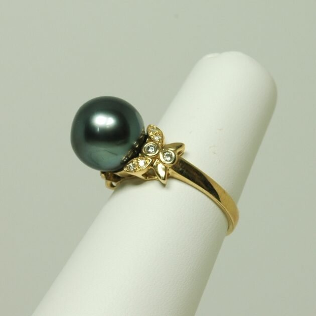 Black pearl ring studded with diamonds.