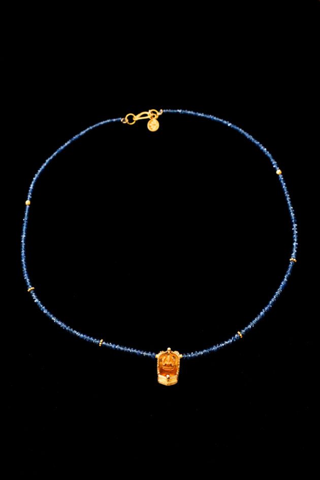 Traditional 22K gold Lakshmi oil lamp pendant on blue sapphire necklace